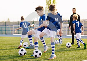 Soccer Training Exercises for Kids. Boys Training with Balls on Summer Football Grass Field