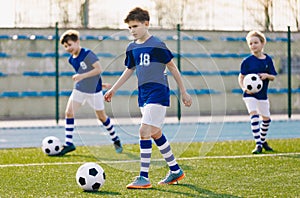 Soccer Training Exercises for Kids. Boys Training with Balls on Summer Football Grass Field