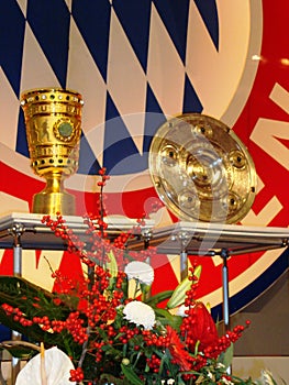 Soccer trophies in front of Bayern Munich Logo