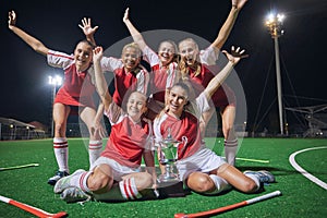 Soccer, trophy and women on a field at night to celebrate teamwork, winning and sports. Football, winner and portrait of