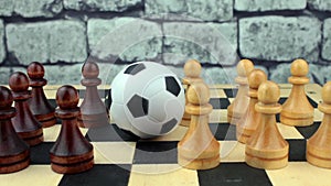 Soccerball among black-and-white pawns