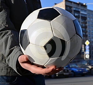 Soccerball in hand of teenager. future champion.