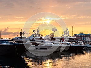 Yachts at the pier in the seaport at sunset