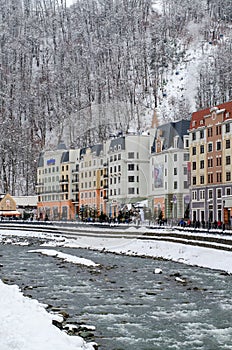 Beautiful buildings near the winter river in a mountain village