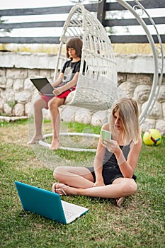 Social alienation of teenagers. Two children with laptop and smartphone