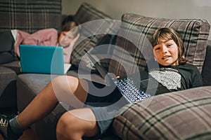 Social alienation of teenagers. Two children using a laptop computer