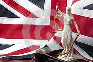 Social contract and the rule of law in the United Kingdom of Great Britain concept theme with statue of goddess Justitia, wooden photo