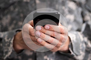 Social Cyber Warfare. Army Soldier Using Phone