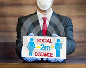 Social distance advice of two metres distance between people with doctor wearing ppe photo