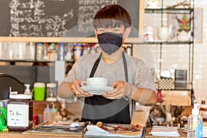 Social distance conceptual small business waiter serving coffee to customer in cafe.