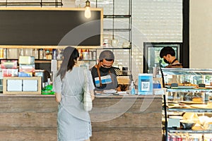 Social distance conceptual small business waiter serving customer in cafe.