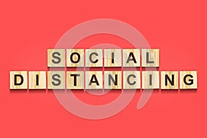 Social distance. The inscription on wooden blocks on a red background.