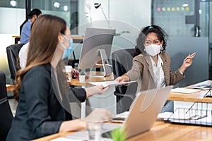 Social distance office with business team wear face mask as new normal life