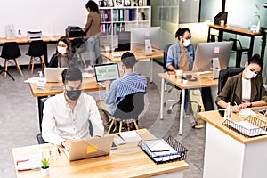 Social distance office with business team wear face mask as new normal life