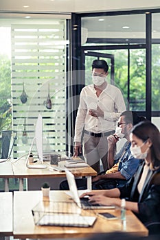 Social distance office with business team wear face mask as new normal life