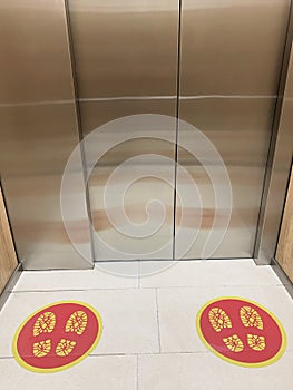 Social distance signs on the floor in the elevator