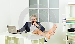 Social distancing concept. man is working at home during coronavirus pandemic. man sit on comfortable chair using laptop