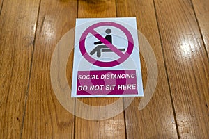 Social distancing and do not sitting caution sign on the bench