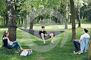 Social distancing. Small group of people enjoying picnic time in accordance with social distancing in summer park. Safety