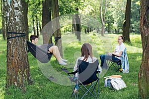 Social distancing. Small group of people enjoying picnic time in accordance with social distancing in summer park. Safety