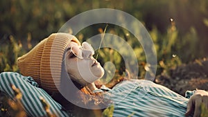 Social distancing and solo activity. Beautiful young girl on self isolation laying on sunset field chewing grass