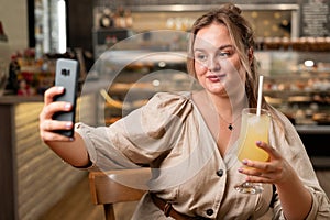 Social influence concept. portrait of lady holding cocktail in hand taking selfie sitting in cafe
