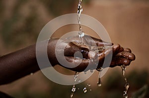 Social Issues: Water Pouring in African Child`s Hands