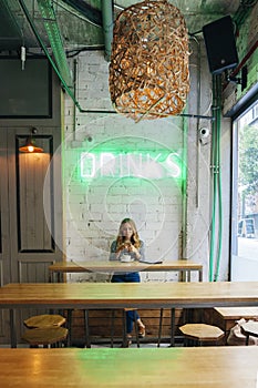 Social media blogger working and having a drink on a restaurant