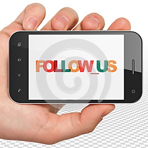 Social media concept: Hand Holding Smartphone with Follow us on display
