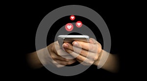 Social media concept. Hands using smartphone with like notification icons. Social networking, black background photo