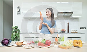 Social media concept. Happy woman standing in kitchen, using camera and recording online video. Happy asian woman vlogger broadcas