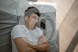 Social media depression. Sad and depressed man lie on the sofa with mobile phone.