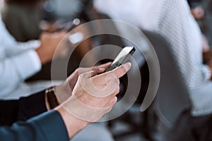 Social media is everywhere, even in a seminar room. a group of businesspeople using their mobile phones during a