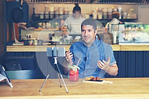 Social media influencer or food blogger creating digital marketing content by filming video inside small business restaurant photo