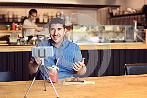 Social media influencer or food blogger creating digital marketing content by filming video inside small business restaurant photo