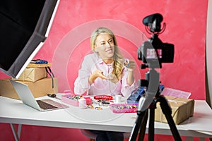 Social media influencer young woman recording video blog with instructional how-to tutorial for making your own jewellery