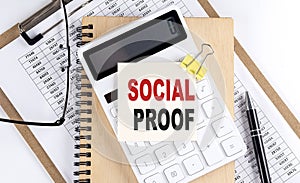 SOCIAL PROOF word on sticky with clipboard and notebook, business concept