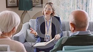 Social worker talking to senior couple at home