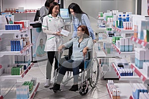 Social worker and wheelchair user in drugstore