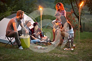 Socializing youngsters in front of tent at night