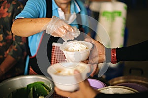 The Society of Sharing Food to Homeless and the Poorest: The Concept of Feeding : The hands of the rich give food to the hands of photo