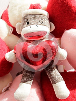 sock monkey with red sparkly heart in hand, celebrate & spread love, peace, joy