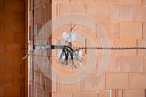 Socket back boxes with wires in a wall. Cabling background. Colorful electrical wires sticking out from electrical sockets.