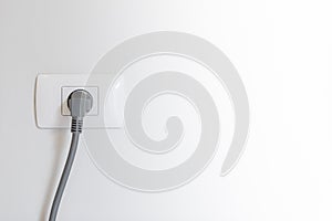 socket plug with electric plug line on white wall