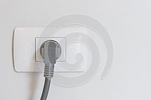 socket plug with electric plug line on white wall