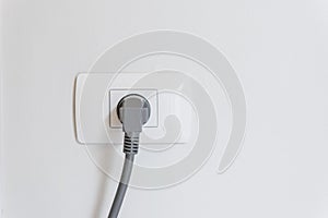 socket plug with electric plug line on white wall