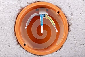 Socket in a raw wall with electric wires. Repair of the electrical installation in the household