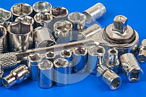 Socket spanner wrench and various wrench heads on a blue surface