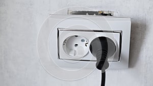 A socket torn from a socket box on a white wall. Risk of Electric Shock, industry. Copy space for text