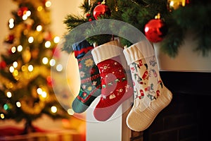 Socks with Christmas gifts near the fireplace on the background of the Christmas tree